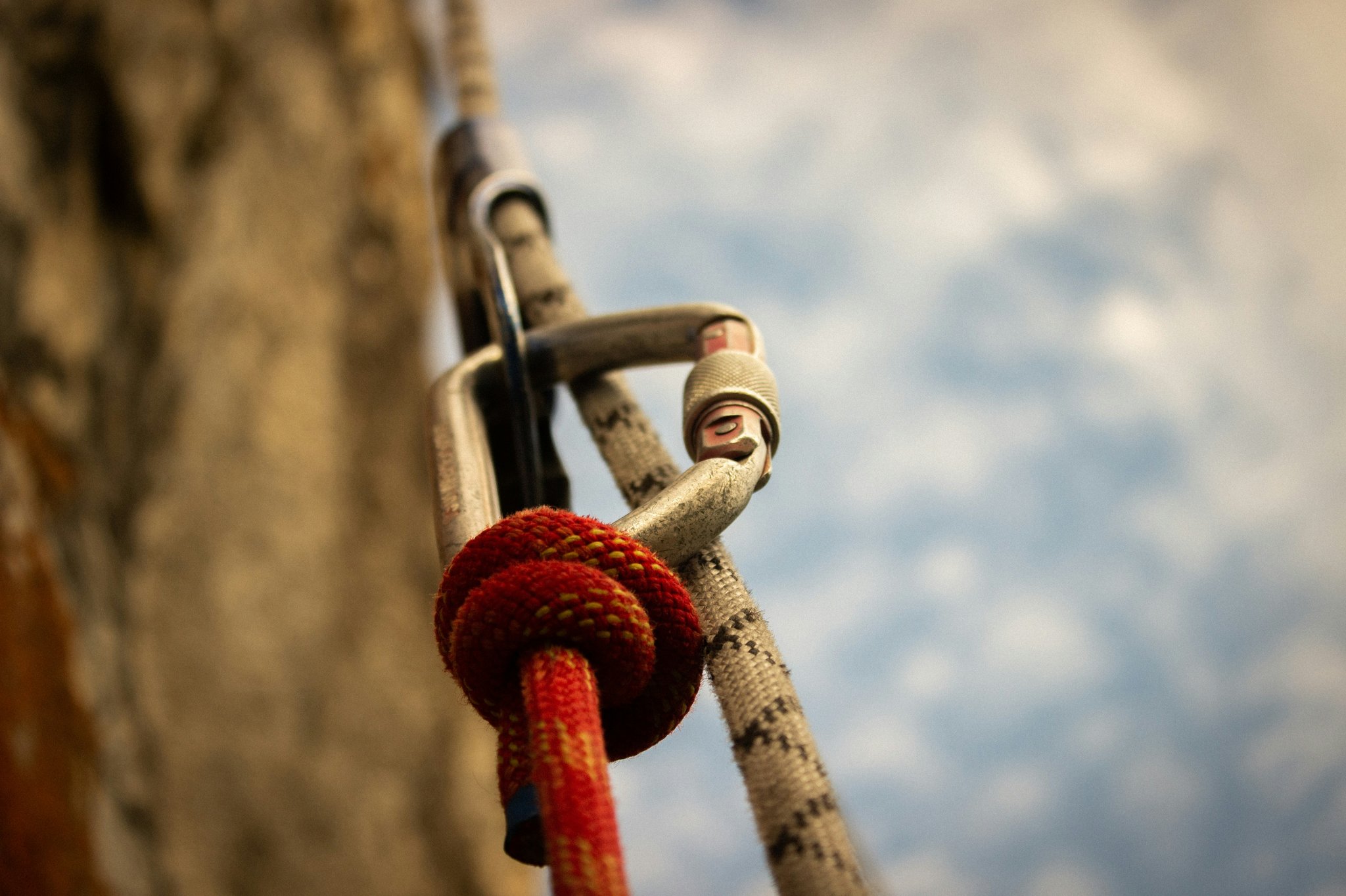 A climber placing a cam into a crack in a rock face